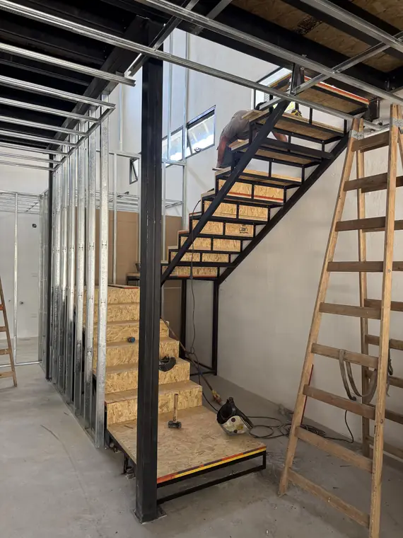 Escalera metálica con escalones de madera en obra